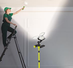 Painter painting a ceiling with light shining upwards