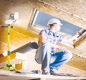 Construction worker illuminating a crawl space